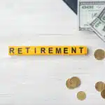 Word "Retirement" and money on light background. Pension planning