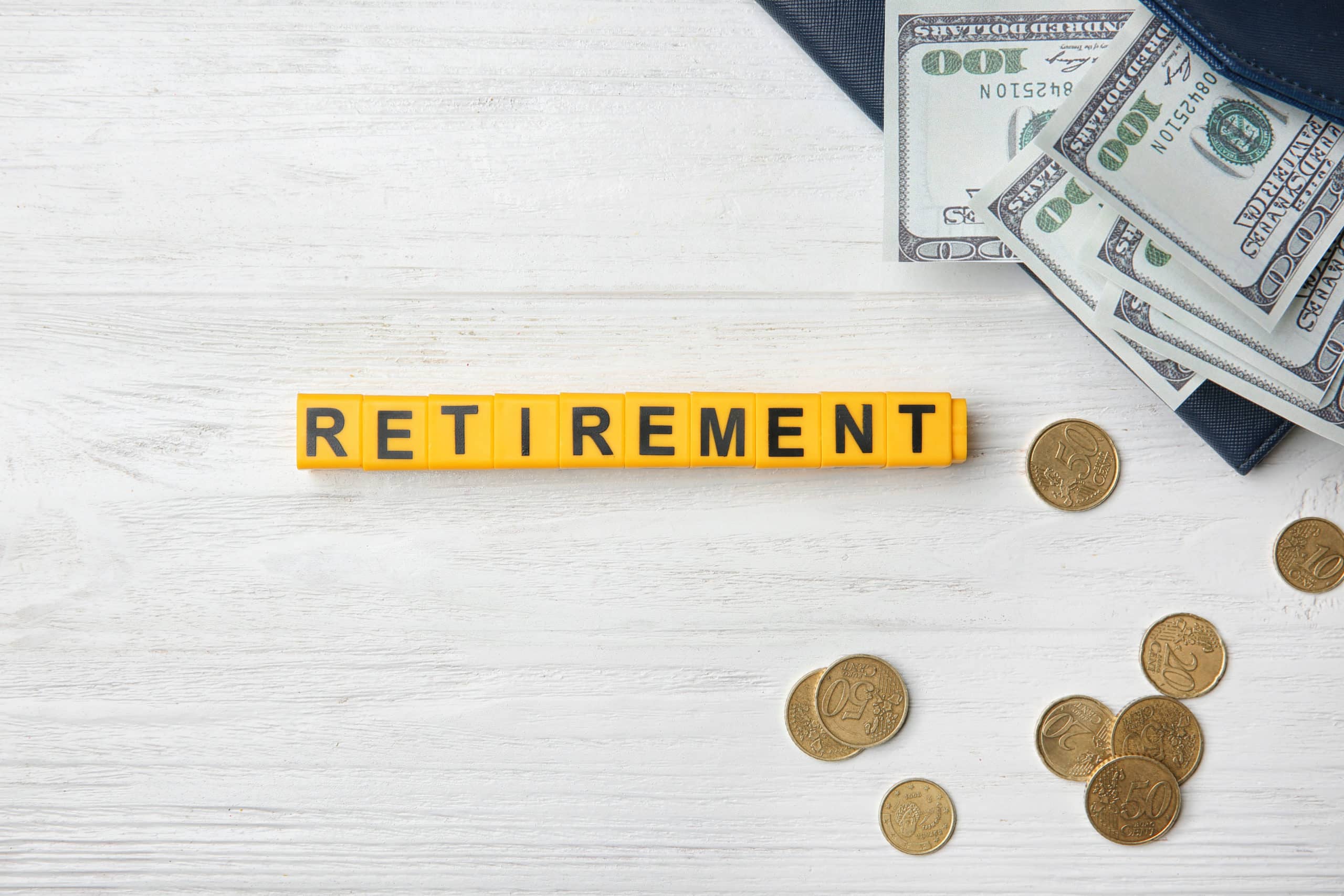Word "Retirement" and money on light background. Pension planning