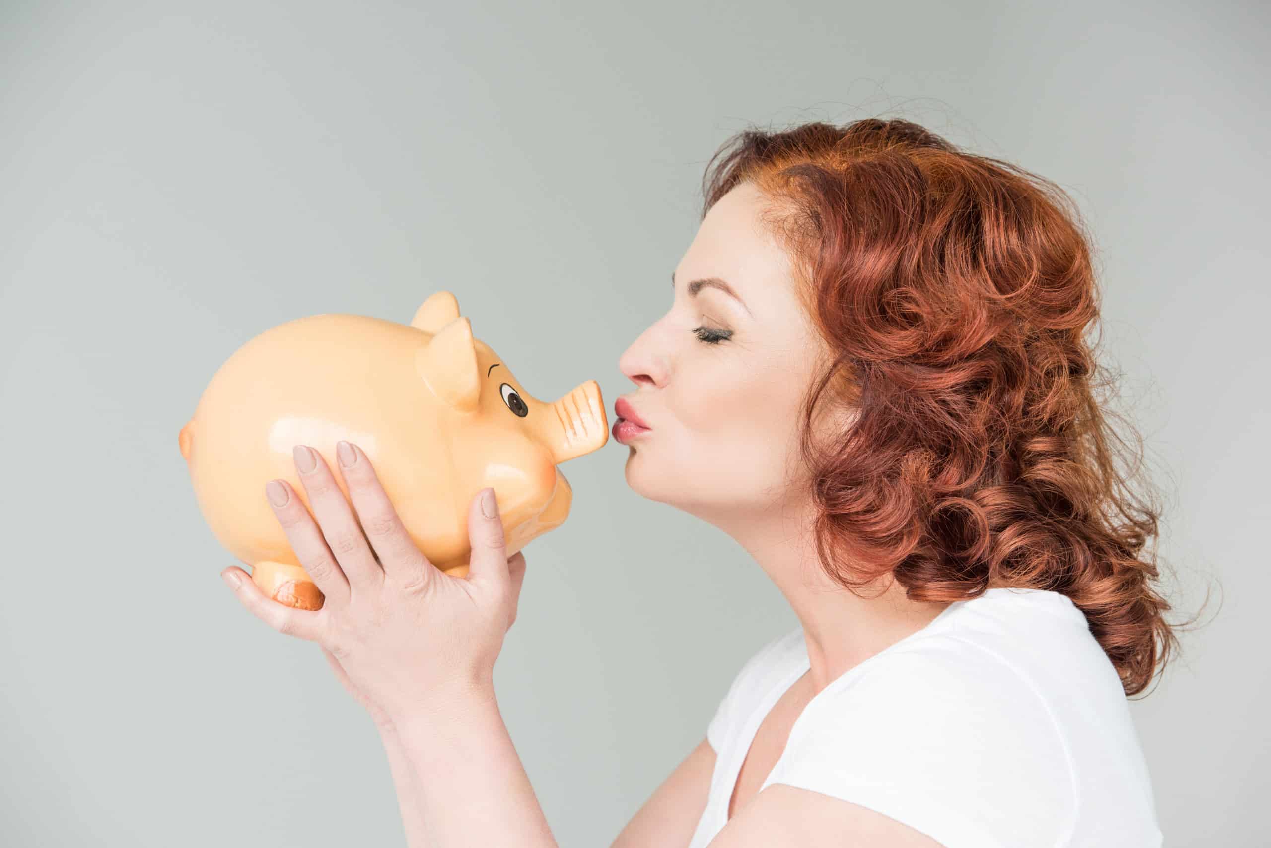 woman kissing a pinking bank she's holding out in front of her