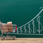 shopping cart with chalkboard of rising prices to demonstrate rising costs of prices during inflation
