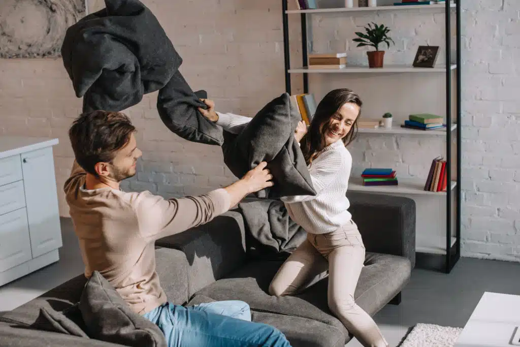 young couple playfully fighting as they discuss investing into apartment buildings 