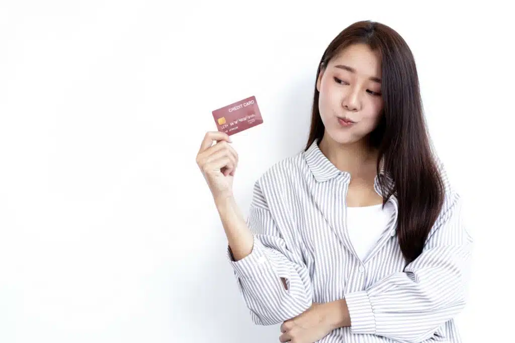 young woman holding a credit card against a white background