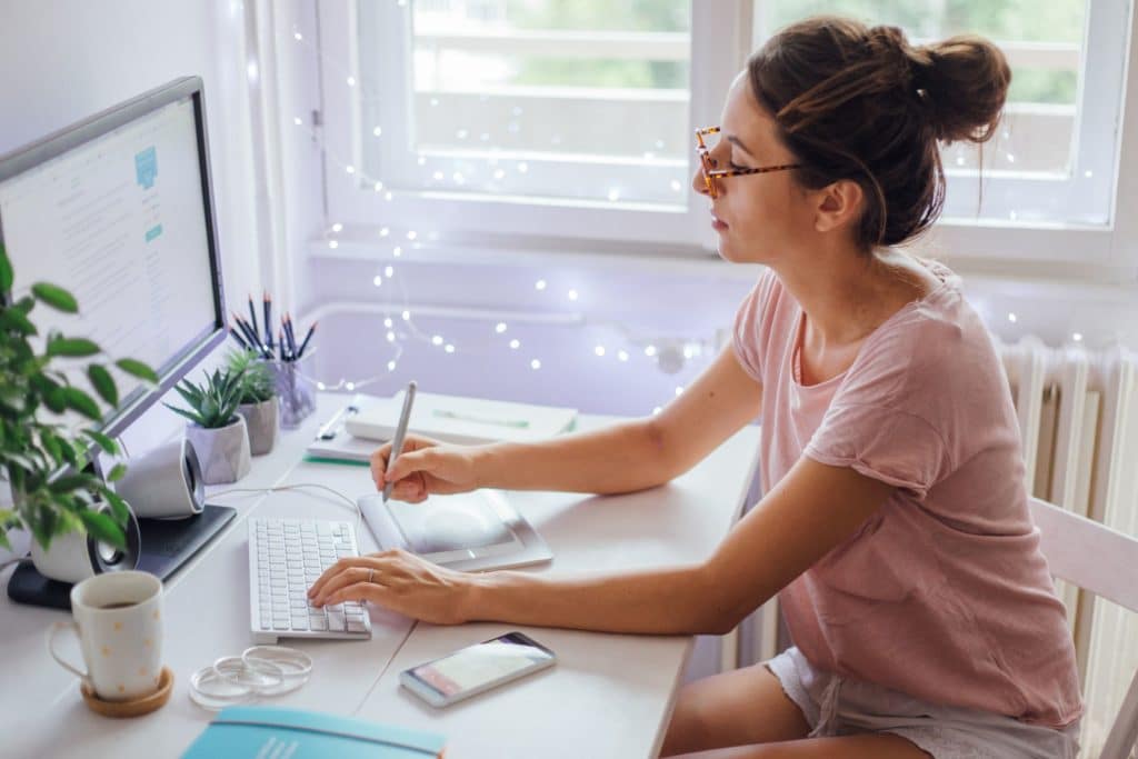 woman sitting at a desk working on a computer 